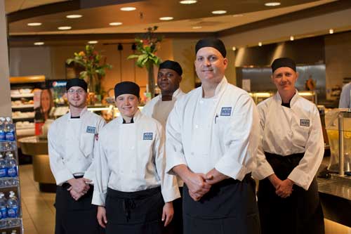 Team of chefs and cooks standing together in a group photo.